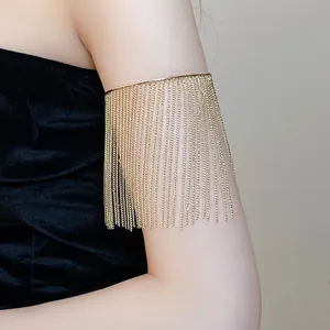 Detailed view of a golden metal arm cuff with elegant long chain tassels on the upper arm