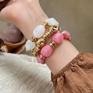 Nahaufnahme von unregelmäßigen geometrischen Acryl-Armbändern mit Goldakzenten am Handgelenk