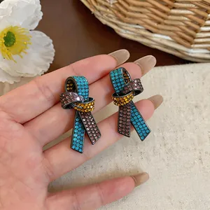Vue macro détaillée d'élégantes boucles d'oreilles nœud en ruban ornées de strass colorés