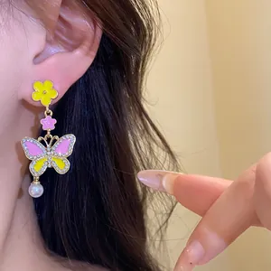 Close-up detail of butterfly and flower earrings with sparkly rhinestones and pearl