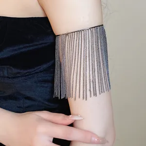 Elegant close-up of metallic chain fringe arm cuff jewelry worn on model's upper arm