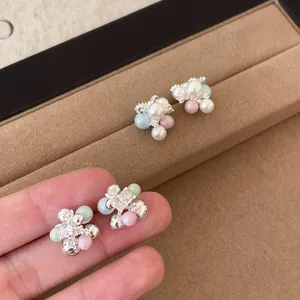 Primo piano di eleganti orecchini a lobo con perle e strass dal design colorato