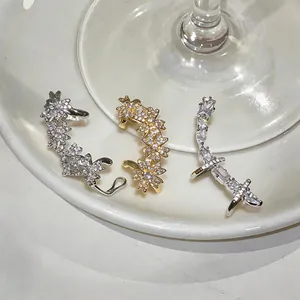 Détail de manchettes d'oreilles en zircone aux motifs floraux et géométriques