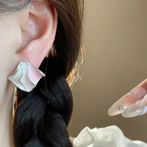 Dettaglio degli orecchini a perno geometrici pieghettati in smalto rosa e bianco