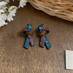 Gros plan de boucles d'oreilles nœud élégantes avec des strass colorés sertis micro