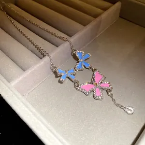 Close-up detail of a sparkling blue and pink butterfly necklace with a crystal tassel drop