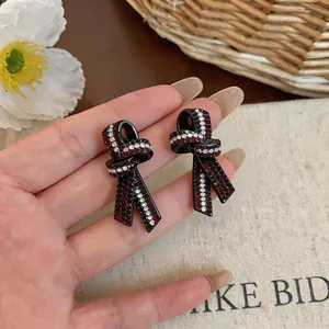 Gros plan détaillé de boucles d'oreilles en nœud avec strass rouges et blancs brillants