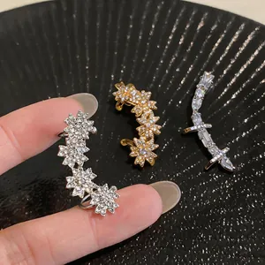 Gros plan détaillé de protège-oreilles élégants en zircon aux motifs floraux et géométriques