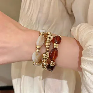 Detailansicht der geometrischen Acryl- und goldfarbenen elastischen Armbänder für Damen