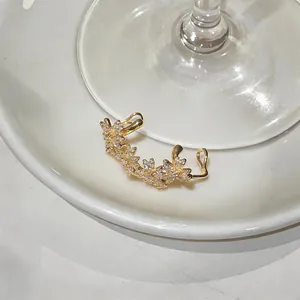 Gros plan détaillé d'un élégant clip d'oreille en zircon doré sur une assiette