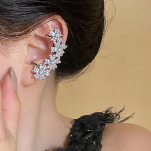 Gros plan d'un ear cuff fleur en zircon argenté élégant porté par un mannequin.