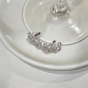 Vue détaillée de manchette d'oreille argentée avec fleurs en zircon scintillantes