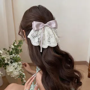 Detailansicht einer eleganten Haarklammer mit Spitze und lavendelfarbener Satinschleife