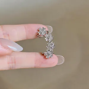 Bague d'oreille fleurie argentée avec zircons étincelants, vue rapprochée.