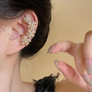 Vue détaillée d'un élégant clip d'oreille fleur avec des zircons brillants sur une oreille