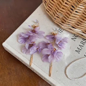 Detailed view of elegant long purple floral earrings with gold-tone metal accents