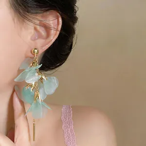 Macro view of elegant mint green petal drop earrings featuring delicate gold accents
