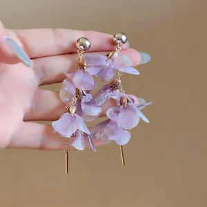 Detailed view of elegant long purple petal dangle earrings with golden accents