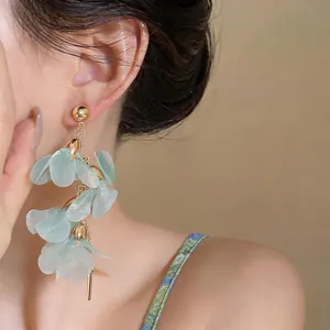 Close-up of elegant long mint green petal earrings worn by an Asian model for summer style