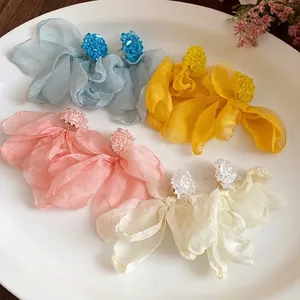 Elegant handmade chiffon flower fringe earrings in multiple pastel colors on a ceramic plate