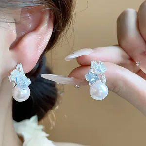 Eleganti orecchini a perla a forma di C con cristalli blu, vista ravvicinata dei dettagli.
