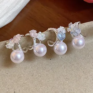 Primo piano dettagliato di eleganti orecchini a C in argento con cristalli e perle rotonde