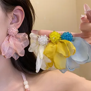 Macro view of elegant colorful chiffon fabric flower drop earrings shown on an Asian model.