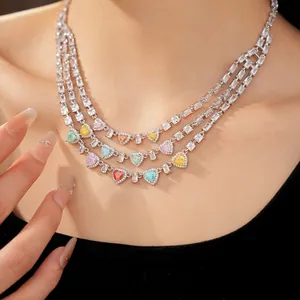 Dettaglio di una collana a più strati con zirconi colorati a cuore e quadrati su modella