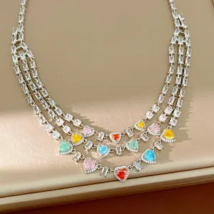 Primo piano di una collana a più strati con zirconi colorati a forma di cuore e quadrati