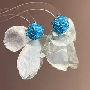 Close-up of elegant light blue chiffon flower earrings with blue beaded centers