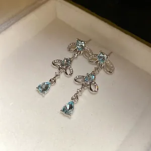 Elegant silver earrings with heart and blue teardrop crystal tassels.