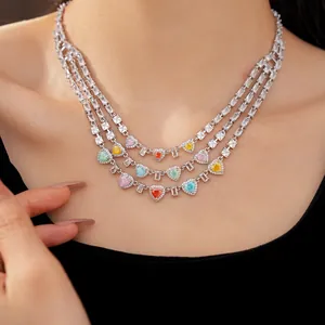 Dettaglio di una collana a tre strati con zirconi colorati a forma di cuore ed eleganti