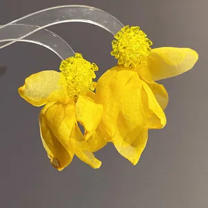 Detail view of vibrant yellow chiffon flower earrings with beaded crystal centers