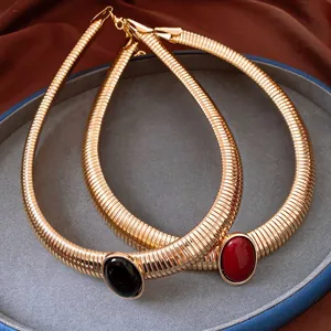 Dettaglio girocolli vintage dorati a spina di serpente con pietre in resina nere e rosse