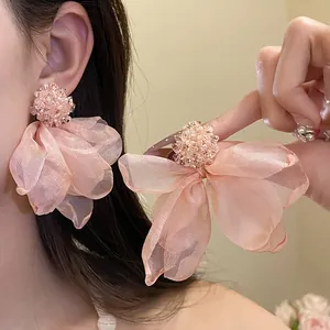 Close-up of elegant pink chiffon flower earrings with delicate beadwork detail