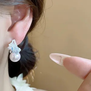 Vista dettagliata di eleganti orecchini a perno in argento a forma di C con perla