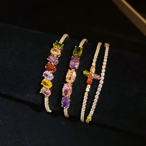Gros plan de bracelets plaqués or 14K avec des pierres CZ colorées et un design floral