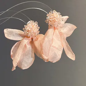 Detailed macro view of elegant pink chiffon flower earrings with sparkling bead accents