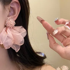Detailed view of elegant pink chiffon fabric flower stud earrings worn on the ear