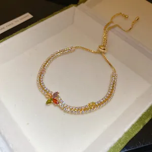 Détail d'un bracelet double rang en plaqué or 14K avec zircons et motif floral