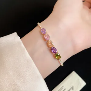 Gros plan élégant d'un bracelet plaqué or 14K avec des zircons ovales multicolores.