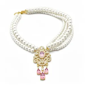 Collana di perle multistrato vintage con ciondolo in pietre rosa e dettagli floreali.