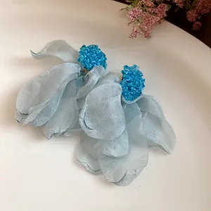 Detailed view of light blue chiffon flower tassel earrings with beaded studs