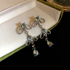 Elegant silver-tone drop earrings featuring blue heart stones and teardrop tassels