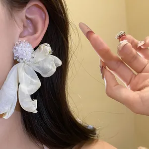 Detailed view of elegant white chiffon flower earrings with a beaded center stud