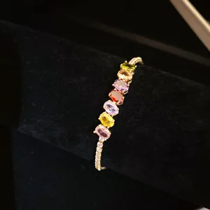 Gros plan d'un bracelet plaqué or 14K orné de pierres de zircone cubique ovales multicolores