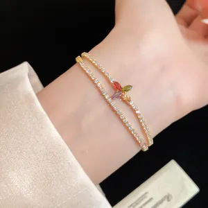 Gros plan d'un bracelet double couche plaqué or 14 carats avec fleur en zircone colorée