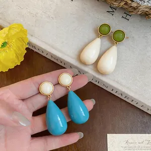 Detailed view of elegant blue resin teardrop earrings with stylish white round studs