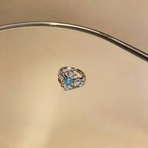 Elegant silver cross ring featuring a central blue zircon gemstone detail