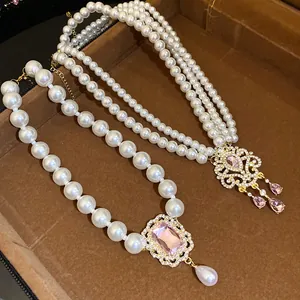 Dettaglio della collana di perle a più strati con ciondolo a fiore in strass